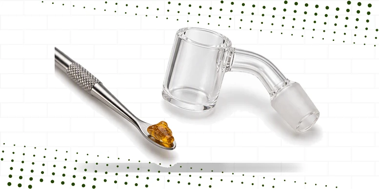 Porção de concentrado âmbar sobre a ferramenta de dab ao lado de um prego de quartzo (banger)