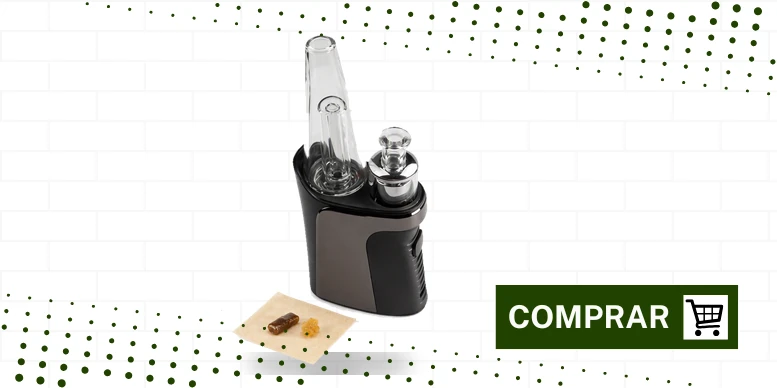 Vaporizador de concentrados Qomo da XVape com bubbler de vidro ao lado de um pequeno bloco de resina sobre papel manteiga